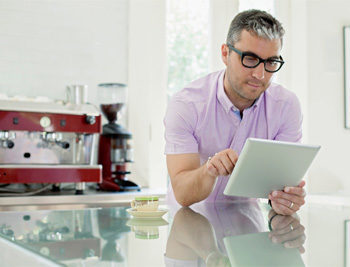Portrait of man using digital tablet in domestic kitchen